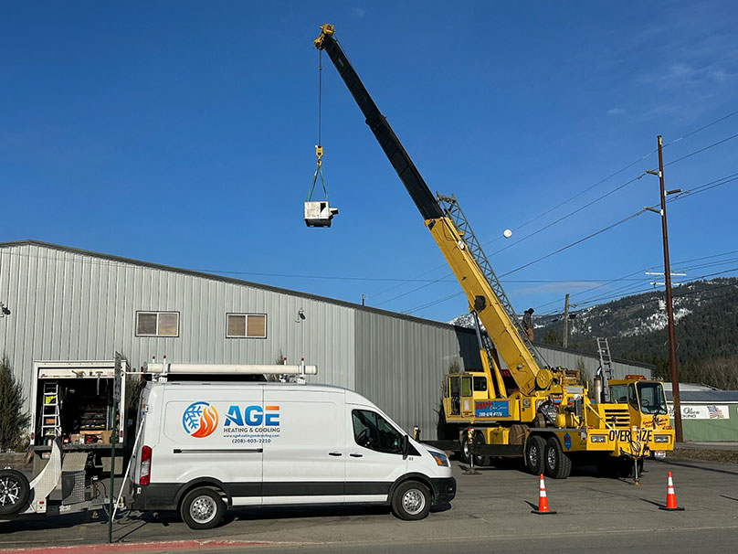 Age van with a crane in the background lifting an air conditioner unit Age van with a crane in the background lifting an air conditioner unit